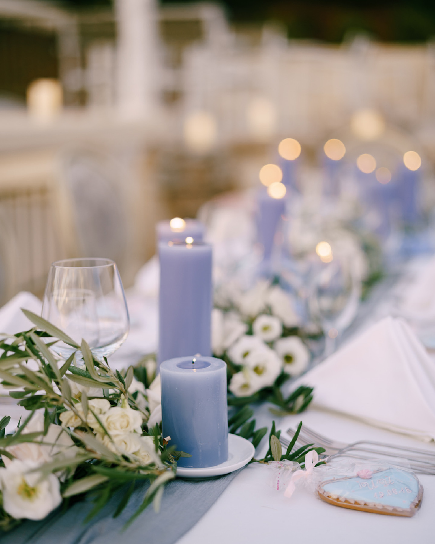 Schön gedeckte Festtafel zur Taufe im Greeery-Stil, mit weißen Blüten und fliederfarbenen Kerzen