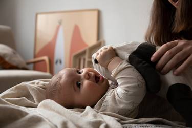 Fröhliches Baby auf einer Kuscheldecke im Wohnzimmer