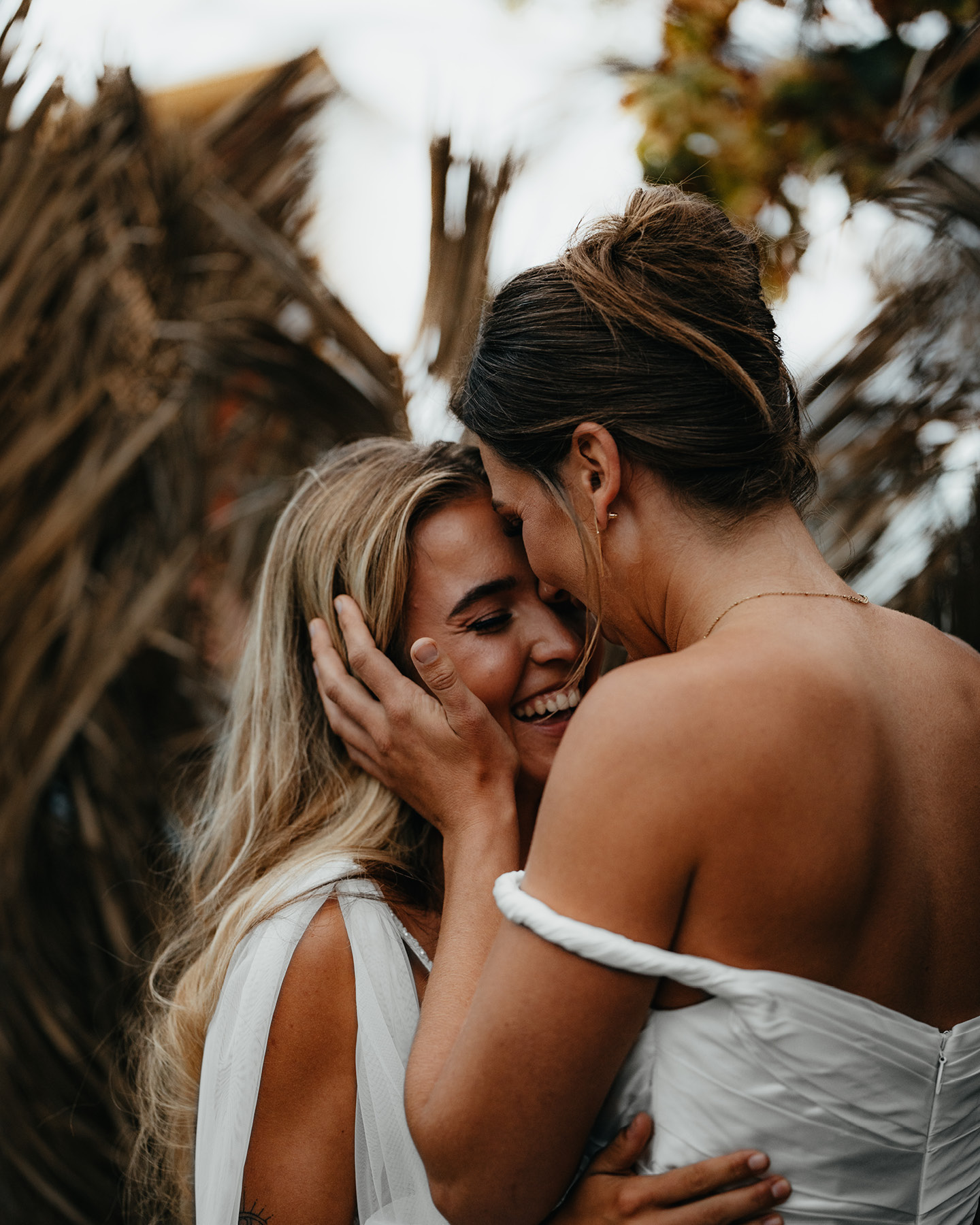 Zwei glückliche Bräute in Hochzeitskleidern in zärtlicher Pose