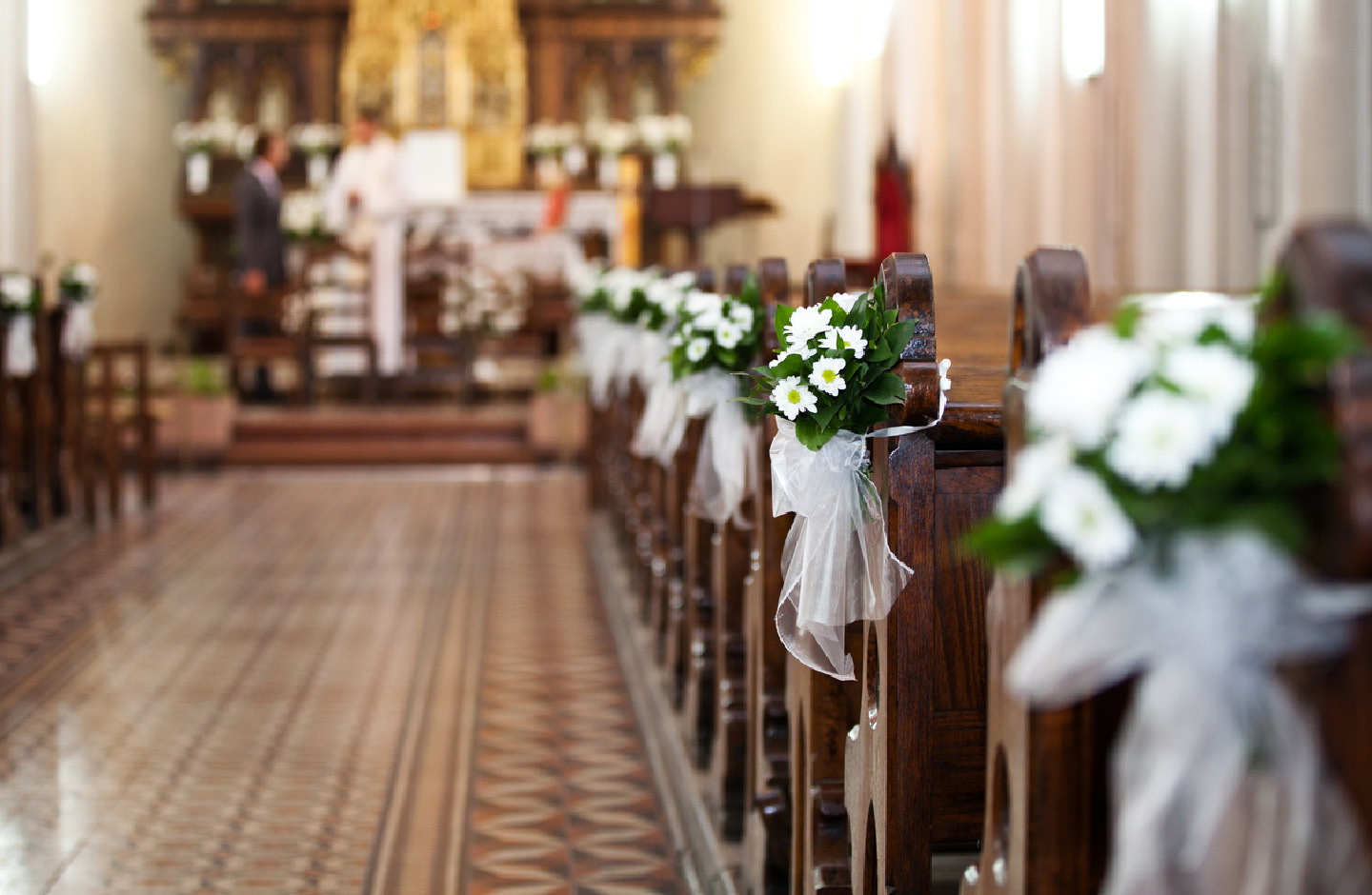 Kirchenbänke mit weißen Blumen und Tüllschleifen geschmückt