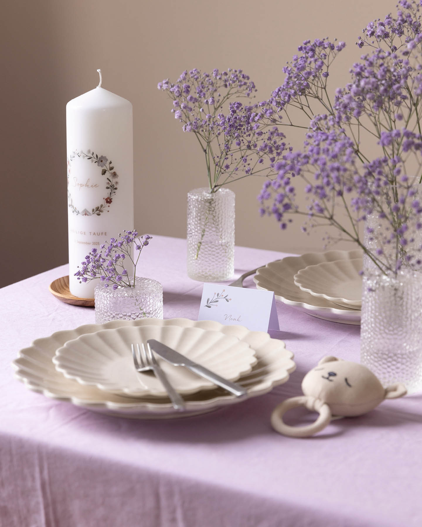 Minimalistische Tischdeko zur Taufe mit Tischkarten, Taufkerze und lila gefärbtem Schleierkraut