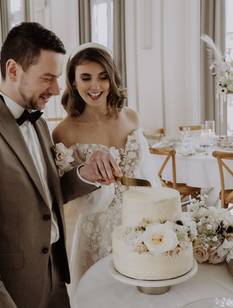 Glückliches Brautpaar schneidet nach der Trauung auf dem Standesamt die Hochzeitstorte an