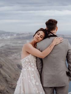 Hochzeitspaar in zärtlicher Pose vor Kulisse von Santorini