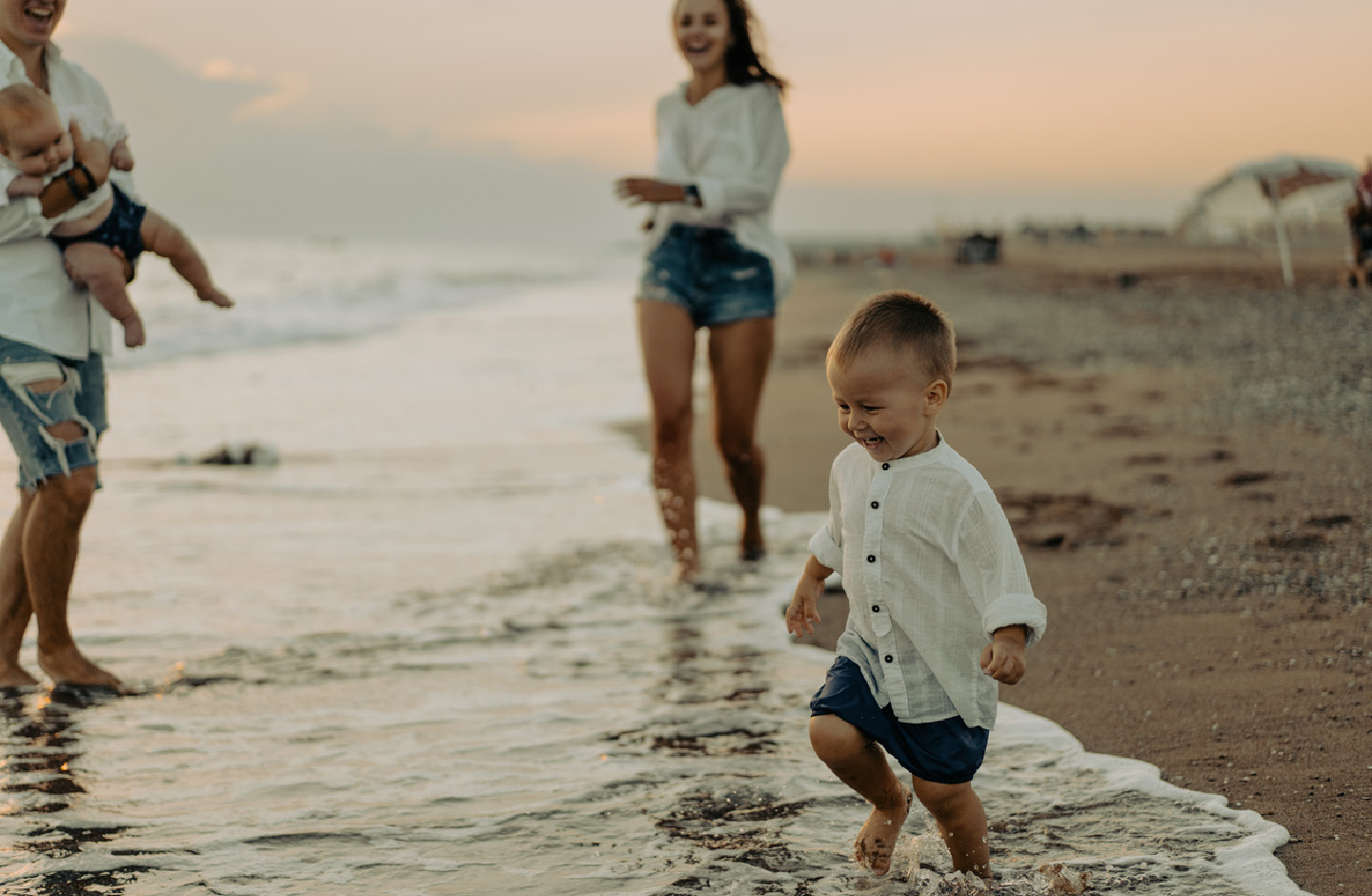 Familie mit zwei kleinen Kindern genießt Zeit am Strand