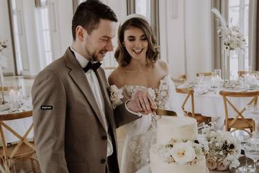 Glückliches Brautpaar schneidet nach der Trauung auf dem Standesamt die Hochzeitstorte an